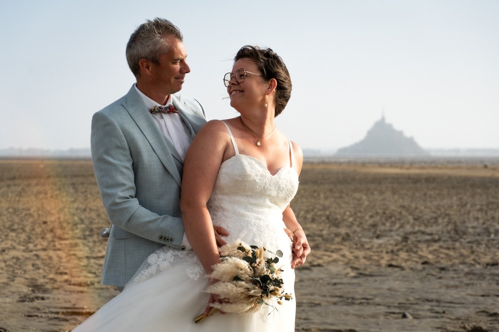 Couple de mariés souriant, le Mont-Saint-Michel en arrière-plan